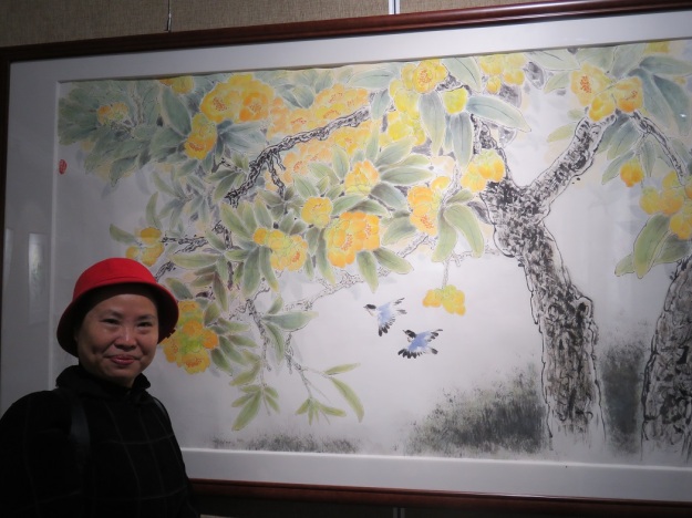 Artist Xinger Li with her lovely painting titled (in English) ‘Chinese Camellia with Dense Dew”